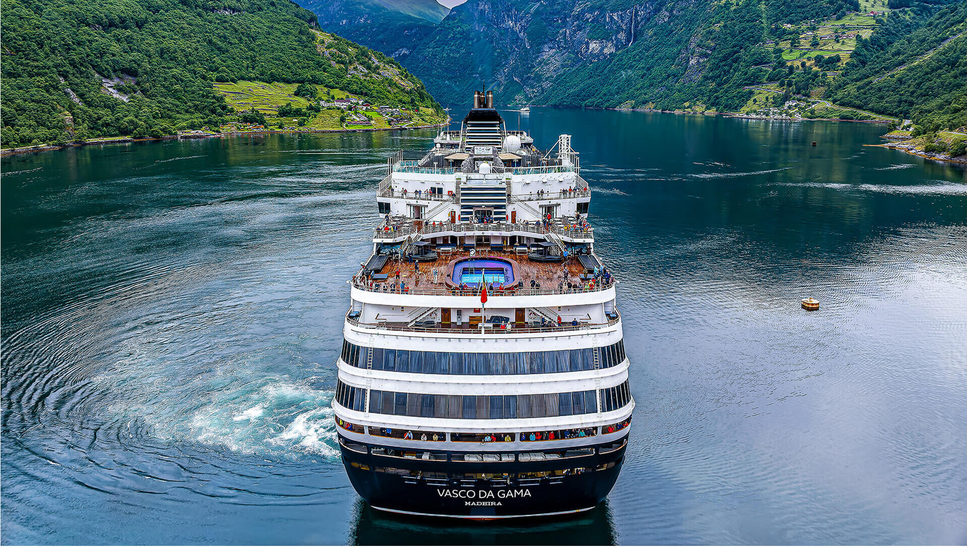 Kreuzfahrtschiff Vasco da Gama fährt in den engen Geirangerfjord, umgeben von steilen grünen Bergen