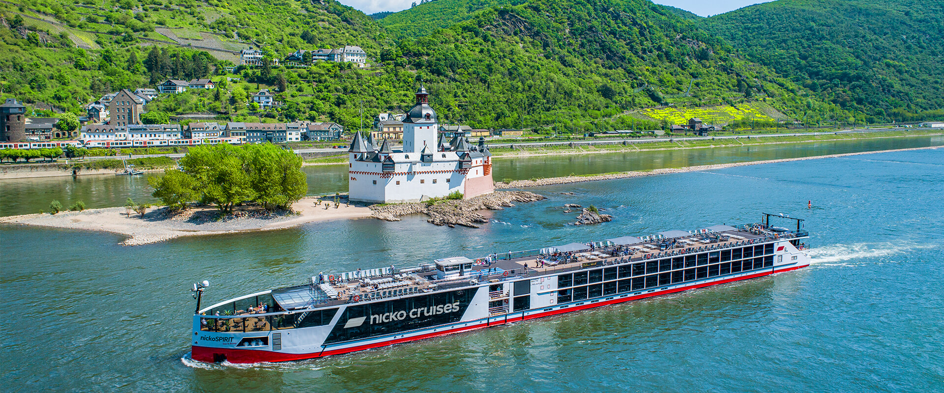 Flusskreuzfahrtschiff 'nicko cruises' auf dem Rhein vor der Pfalzgrafenstein Festung und grünen Weinbergen